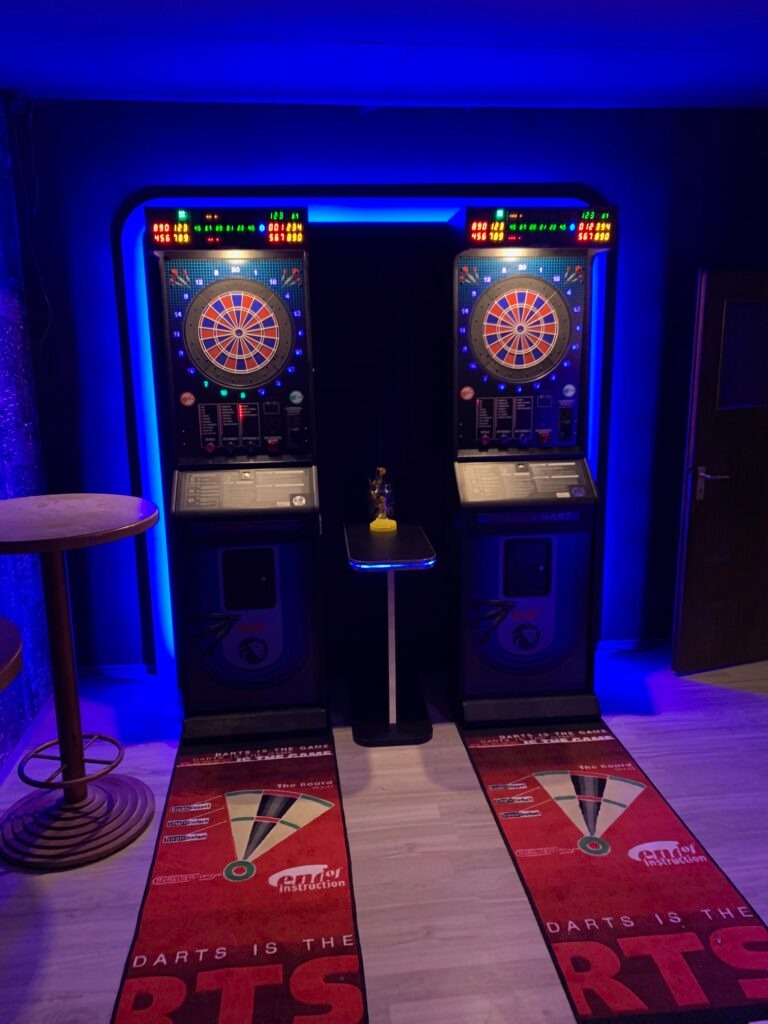Zwei elektronische Dart-Automaten mit blauer LED-Beleuchtung und Spielmatten